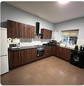 a kitchen with wooden cabinets and a stove top oven at EQU London in Ilford