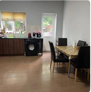 a kitchen and dining room with a table and chairs at EQU London in Ilford