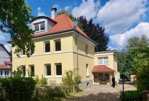 a large yellow house with a red roof at Little Lopsi in Detmold