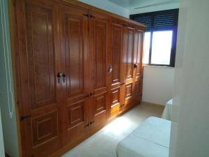 a large wooden cabinet in a room with a window at Ático Luminoso Cerca De Cala Accesible Y Tranquila in Valverde