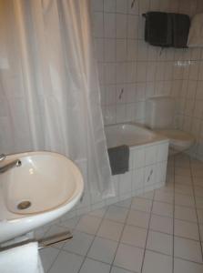 un bagno con lavandino, vasca e WC di South Facing Family Chalet in Saanen Village a Gstaad