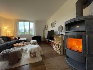 a living room with a fireplace in the middle of it at Lovely 4 Bedroom Chalet Great for Ski Holiday in Saanenmöser