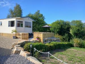 BallintraBella May Mobile Home的一座带围栏和花园的小房子