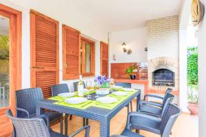 a dining room with a table and chairs and a fireplace at Villa Joaquina in Port d'Addaia