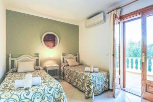 a bedroom with two beds and a balcony at Villa Joaquina in Port d'Addaia +11 photos