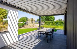 a deck with a table and chairs on a patio at 2 Bedroom Amazing Home In Voorthuizen in Voorthuizen +23 photos
