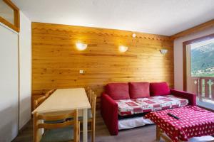 a room with a couch and a table and a table and chair at A3 209 Appart au pied des pistes in Saint-François-Longchamp