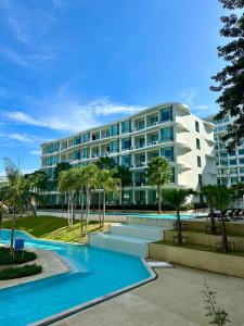 a large building with a pool in front of it at La Vita Luxury Apartment in Rawai Beach