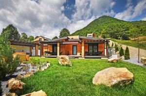 a house on a hill with a yard with rocks at Casa Twins - Slanic Moldova in Slănic-Moldova