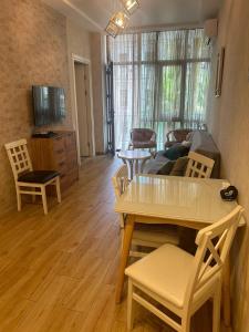 a living room with a table and chairs and a couch at Parso Apartment in Batumi