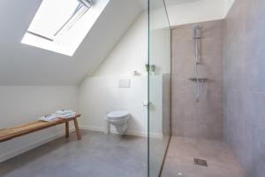 a bathroom with a toilet and a glass shower at Hotel Bla Bla in Bruges