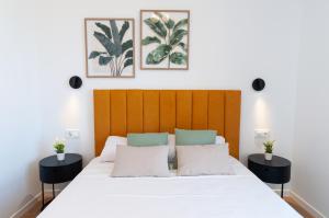 a bedroom with a large white bed with two tables at Myflats Campello Beach in El Campello +117 photos
