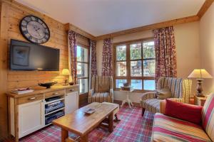 a living room with a tv and a table at ARC 1950, Appartement 2 chambres, 6 personnes in Arc 1950