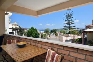a balcony with a wooden table on a brick wall at Favola Golden Beach Villa in Daratso