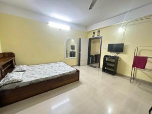DispurDreams Abode 01 STUDIO APARTMENT的一间带床和平板电视的卧室