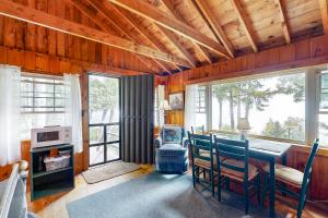 a dining room with a table and chairs and windows at Evergreen in Northport