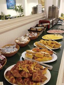 a table with many different types of pastries on plates at ATLAS TOWER HOTEL in Buenos Aires