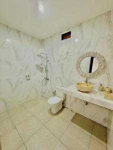a bathroom with a toilet and a sink and a mirror at Volcano cottage bali in Kubupenlokan