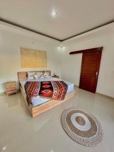 a bedroom with a bed and a rug on the floor at Volcano cottage bali in Kubupenlokan +7 photos