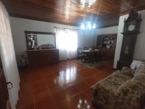 a living room with a clock and a table with chairs at Varanda do Sardoal in Penafiel