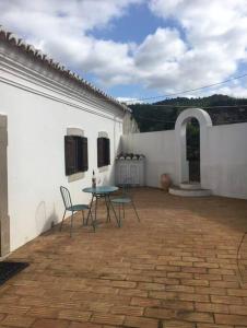 Un patio con una mesa y sillas en un edificio. en San Salvatore, en Querença
