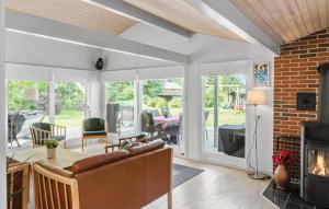 Bøtø ByにあるAmazing Home In Væggerløse With Wifiの暖炉とテーブルと椅子のあるリビングルーム