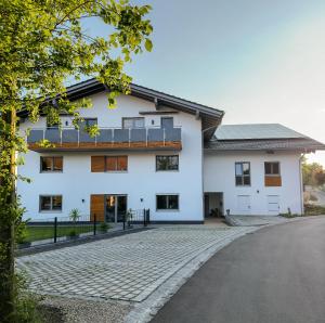 a white house with a driveway at Beim Huber in Hopferau
