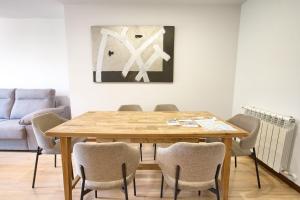 a dining room with a wooden table and chairs at Cuencaloft Villacuenca in Cuenca