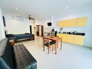 Una cocina y una sala de estar con una mesa y un sofá. en Coastal Oasis - Poolside Retreat, en Nathon Bay