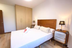 a bedroom with a large white bed and a lamp at Cuencaloft Villacuenca in Cuenca +43 photos