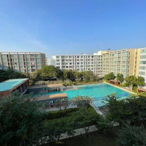 a large swimming pool in front of a large building at D condo sign D4 in Chiang Mai