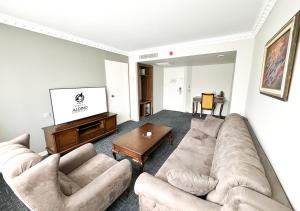 a living room with two couches and a flat screen tv at Aldino Hotel & Spa in Ankara