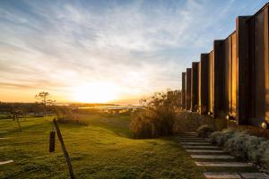 um edifício com um pôr do sol ao fundo em Areias do Seixo Hotel em Santa Cruz