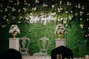 a green wall with two chairs and flowers at Aldino Hotel & Spa in Ankara