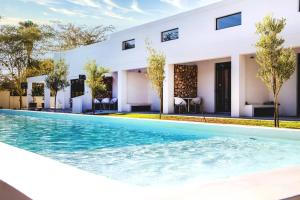 an image of a swimming pool in front of a house at Karoo Retreat- Self Catering Villas and Guest House in Oudtshoorn