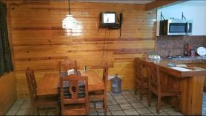 a kitchen with a wooden wall with a table and chairs at Cabaña Mazamitla #6 David's in Mazamitla