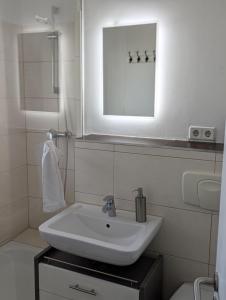 a white bathroom with a sink and a mirror at Ferienwohnung Oker - City Center - Keybox and Balkony in Braunschweig
