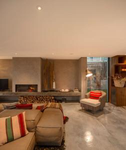a living room with a couch and a fireplace at Areias do Seixo Villas in Santa Cruz