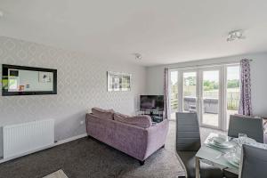 a living room with a purple couch and a table at Auchenlarie Courtyard No 4 in Gatehouse of Fleet