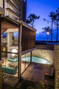 a house with a swimming pool in front of a building at Areias do Seixo Villas in Santa Cruz