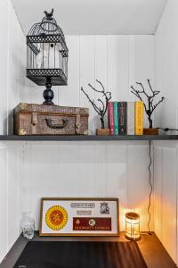 ein Regal mit einer Kiste und einem Vogelkäfig und Büchern in der Unterkunft Harry Potters Hideaway- Walking distance to golf course, food, coffee, shops, ice cream, athletic club and more! in East Flagstaff