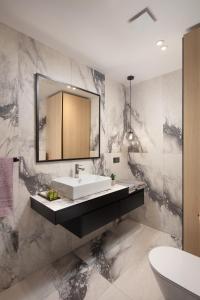 a bathroom with a sink and a mirror at Navona Apartment in Labin