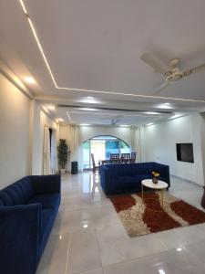 a living room with blue couches and a table at Bhaktivilla in Talegaon Dābhāde +18 photos