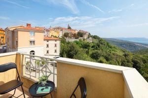 a balcony with chairs and a view of a city at Navona Apartment in Labin
