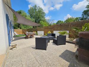 eine Terrasse mit Stühlen, einem Tisch und einem Zaun in der Unterkunft Charmante Maison à 500m de la plage in La Tranche-sur-Mer