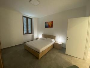 a bedroom with a bed and a window and a door at Casa Paolo in Bellano