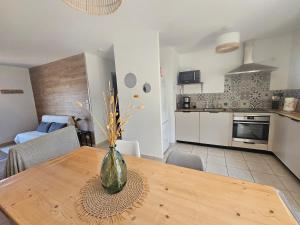 eine Vase auf einem Holztisch in einer Küche in der Unterkunft Charmante Maison à 500m de la plage in La Tranche-sur-Mer