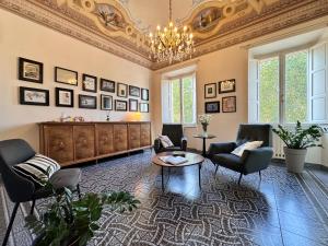 a large living room with chairs and a chandelier at Le Muse in Pisa