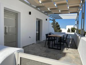 a patio with a table and chairs on a balcony at Santozen Suites in Fira