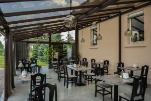 a dining room with tables and chairs and windows at Armenia in Garliava